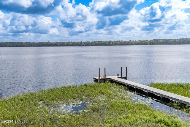 a backyard of a house with lots of green space and lake view