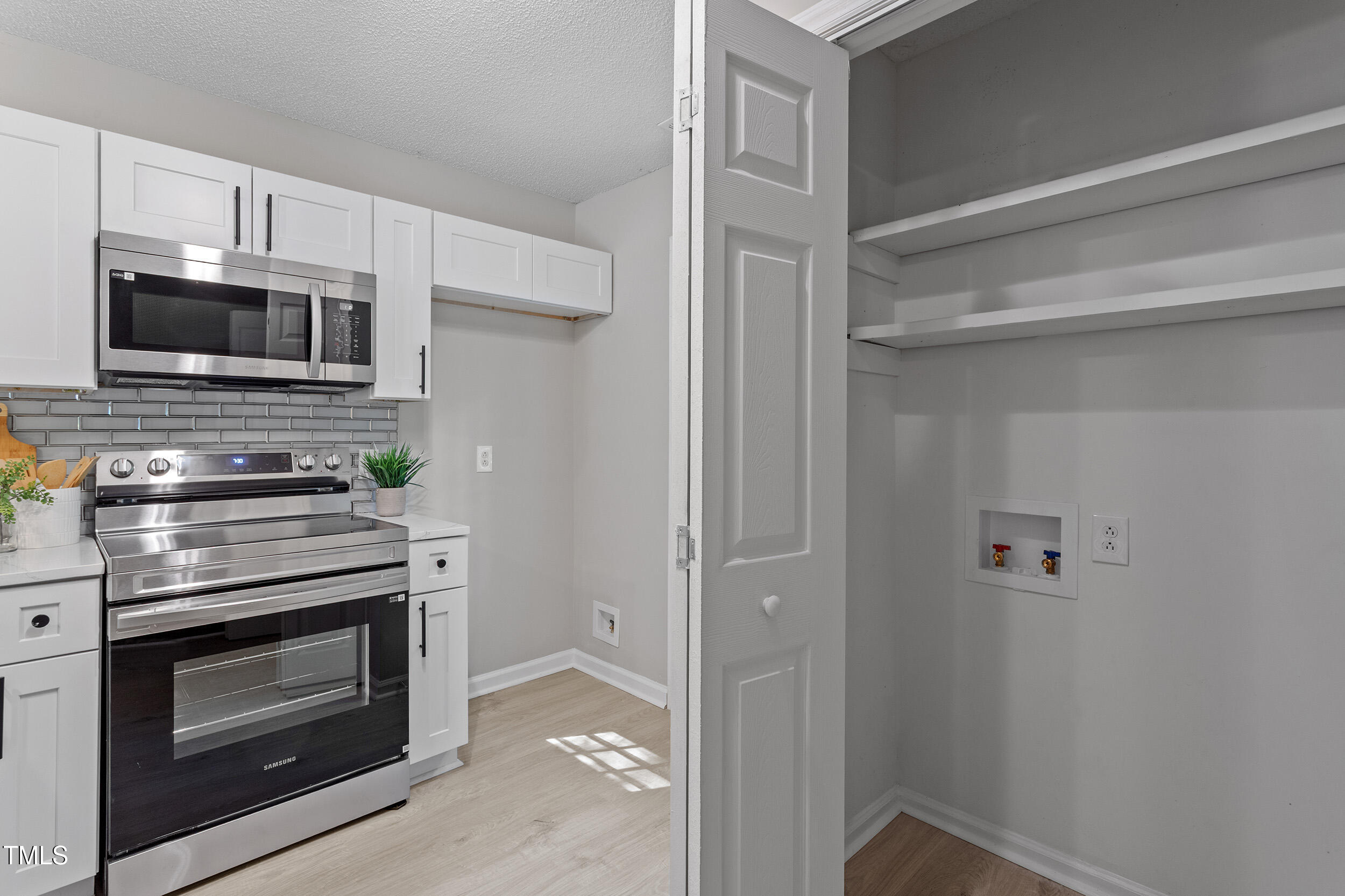 4242 Kaplan Drive Raleigh, NC 27606 - Photo 10 of 30 a kitchen with white cabinets and stainless steel appliances