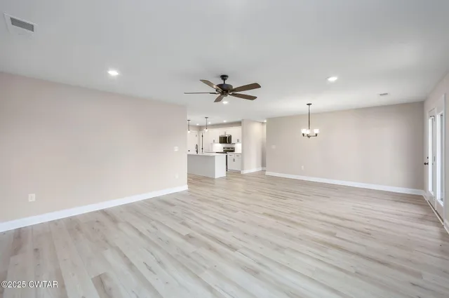 a view of a livingroom with a hardwood floor and a ceiling fan