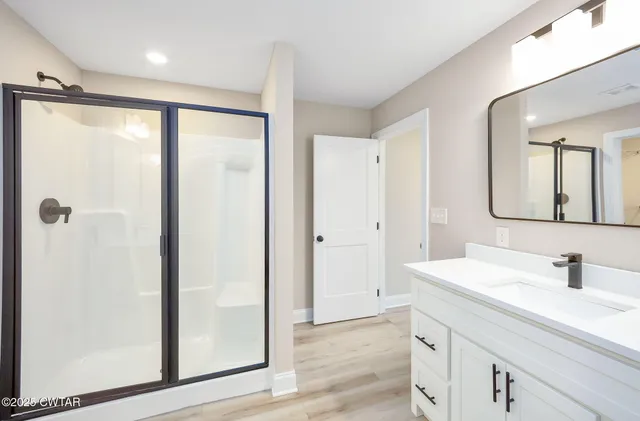 a bathroom with a shower sink and mirror