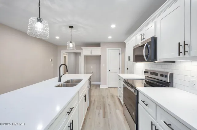 a kitchen that has a lot of cabinets and wooden floor