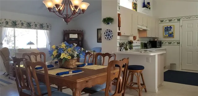 a view of a dining room with furniture a chandelier and window