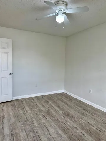 a view of an empty room with a chandelier fan