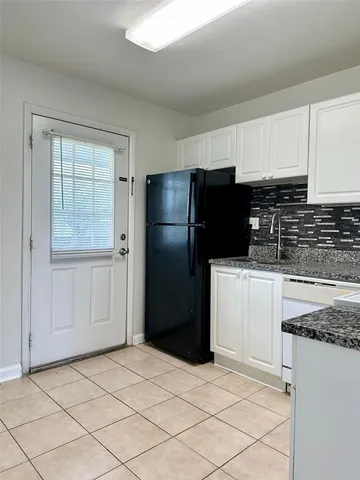 a kitchen with a refrigerator and cabinets