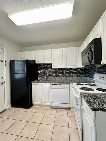 a kitchen with stainless steel appliances granite countertop a stove a refrigerator and a microwave