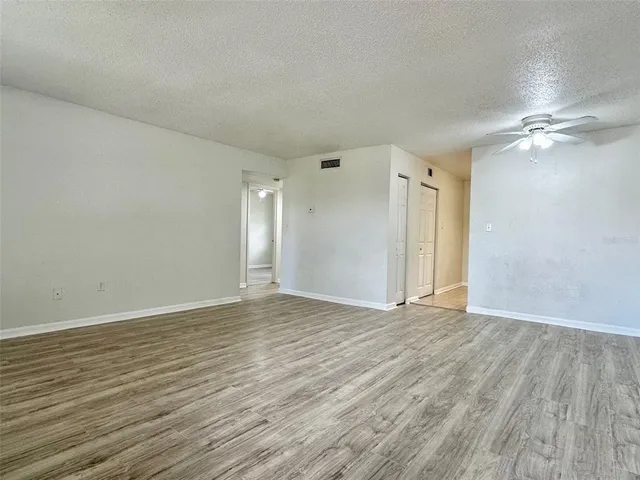 a view of an empty room with wooden floor
