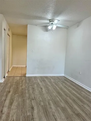 a view of an empty room with wooden floor