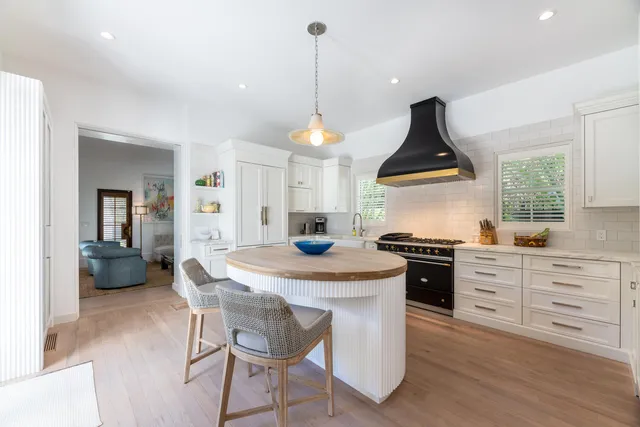 a kitchen with a stove a sink a dining table and chairs