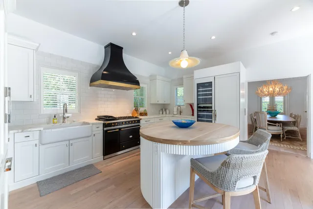 a kitchen with a stove a sink a dining table and chairs