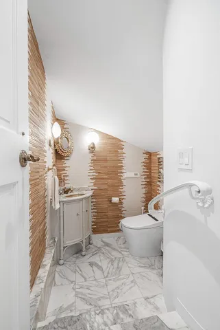 a bathroom with a granite countertop toilet and a sink