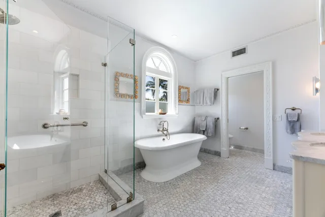 a spacious bedroom with a large bed and a chandelier