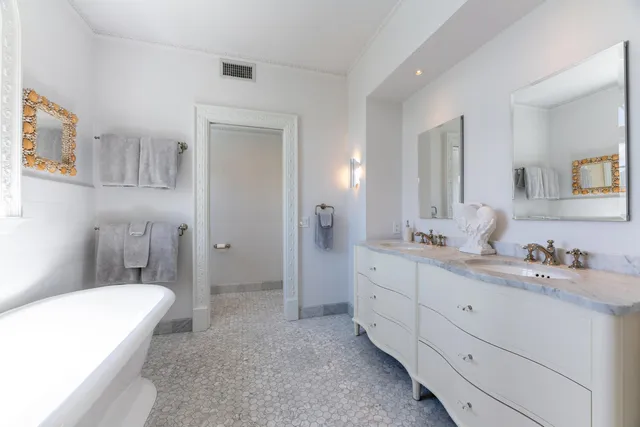 a spacious bedroom with a bed and a dresser next to a window