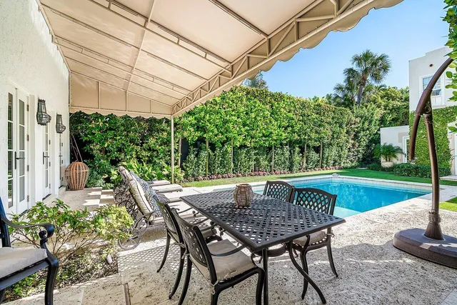 a view of a house with swimming pool lawn chairs and a yard