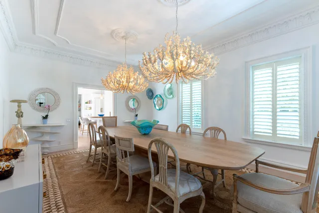 a view of a dining room with furniture a chandelier and window