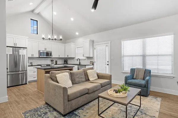 a view of kitchen with kitchen island stainless steel appliances refrigerator stove dining table and chairs