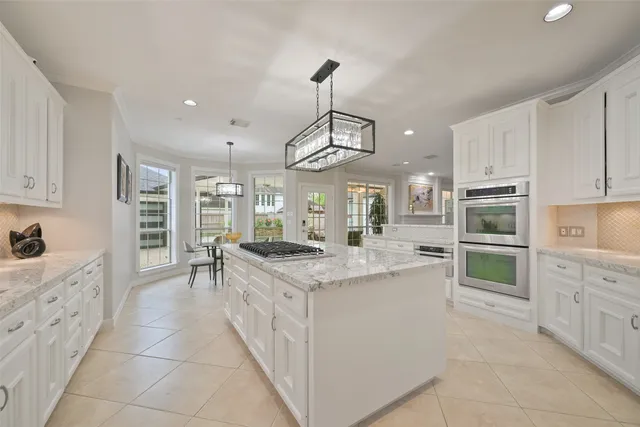 a kitchen with stainless steel appliances kitchen island granite countertop a stove and cabinets