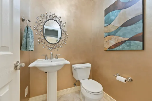 a bathroom with a toilet sink and mirror