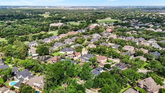 an aerial view of a houses with a lush green hillside