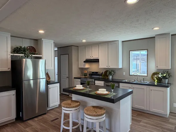 a kitchen with a sink refrigerator and cabinets