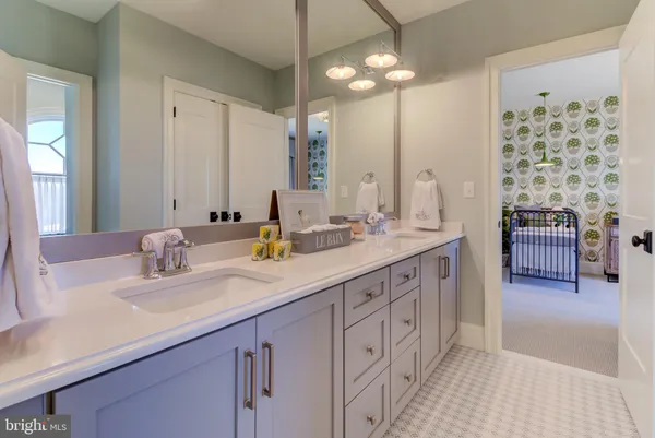 a bathroom with double vanity sinks a vanity a lamp and a mirror