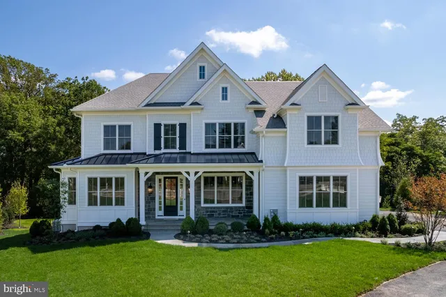 a front view of a house with a yard and trees