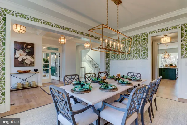 a view of a dining room and livingroom with furniture wooden floor a chandelier