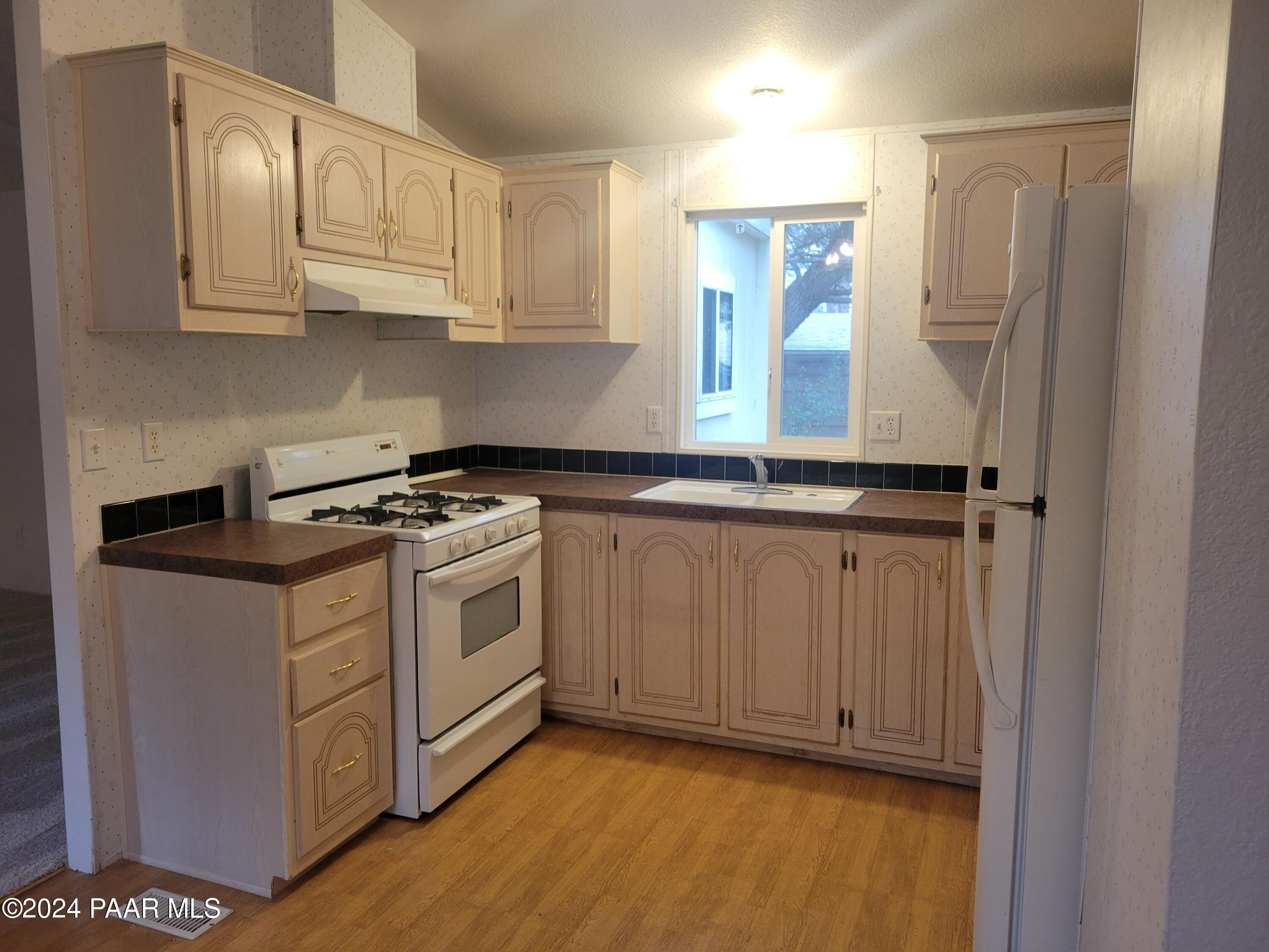 99 Alpine Prescott, AZ 86305 - Photo 8 of 25 a kitchen with granite countertop a sink a stove and cabinets