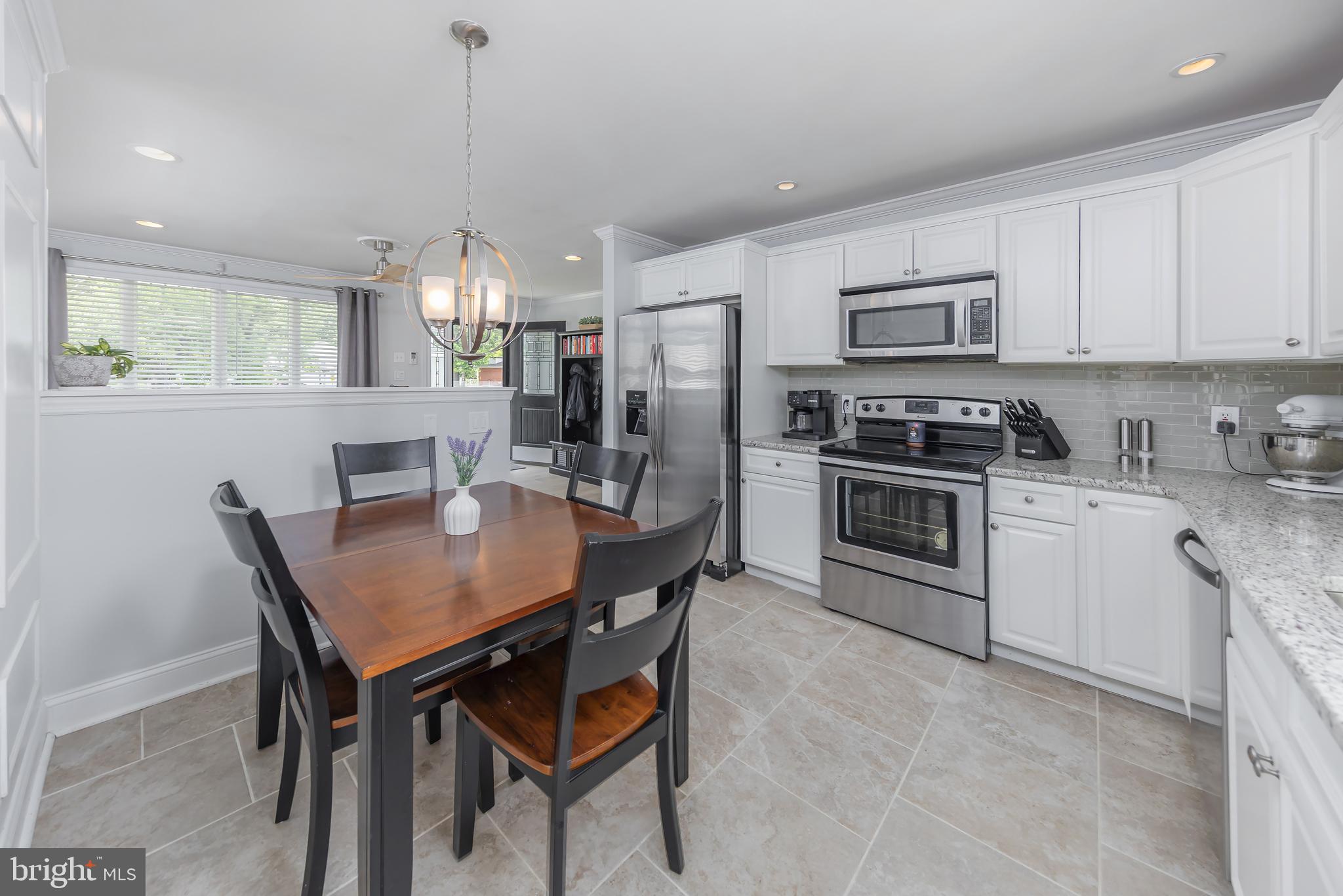 31 Hill Drive Pine Hill, NJ 08021 - Photo 6 of 27 a kitchen with stainless steel appliances a dining table chairs stove refrigerator and cabinets
