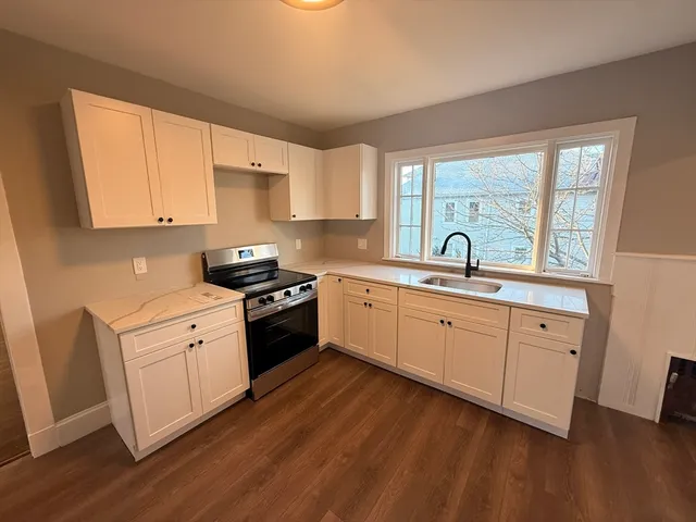 a kitchen with sink stove and cabinets