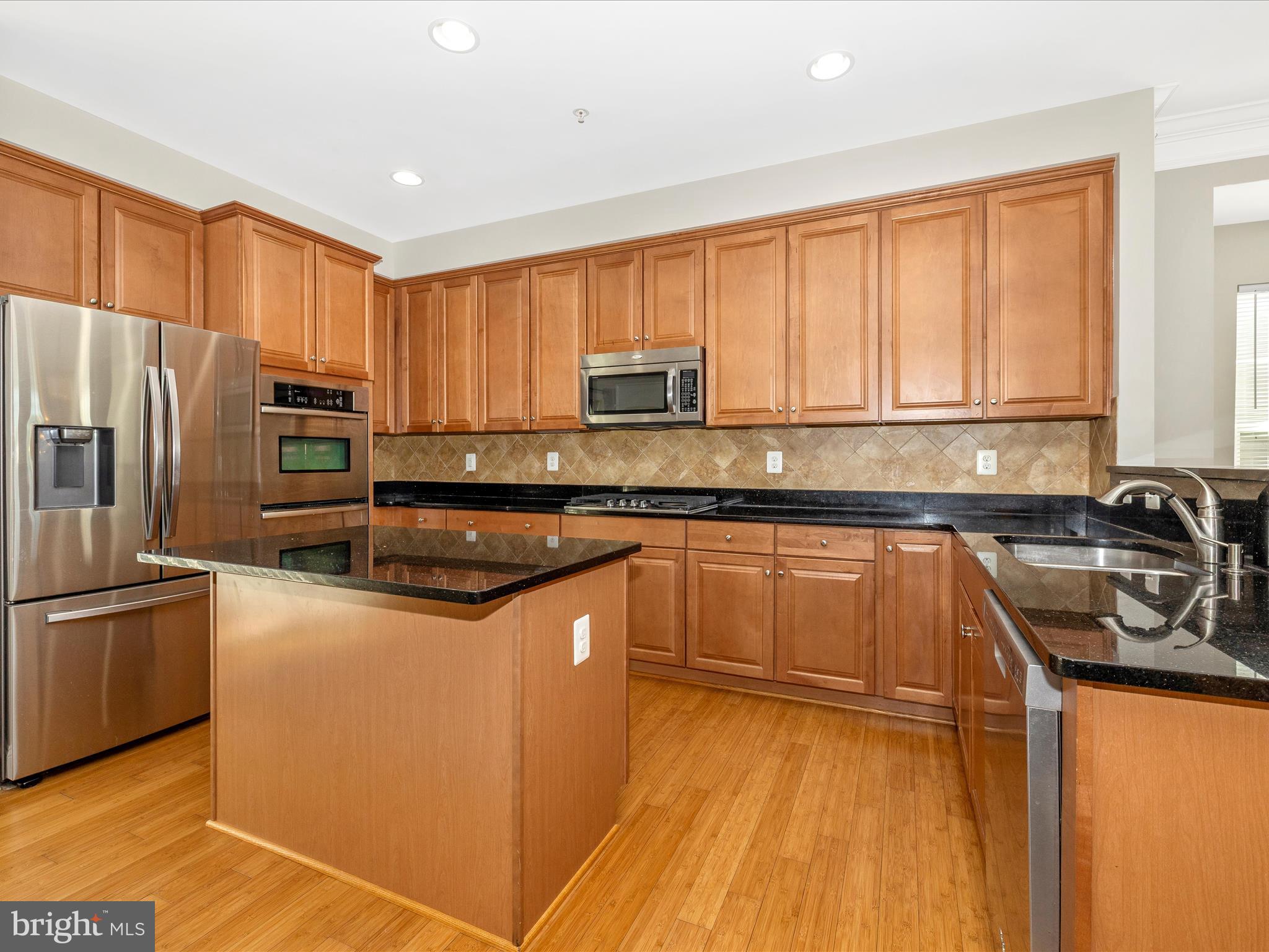7801 Wormans Mill Road Frederick, MD 21701 - Photo 12 of 35 a kitchen with granite countertop a refrigerator stove top oven and sink