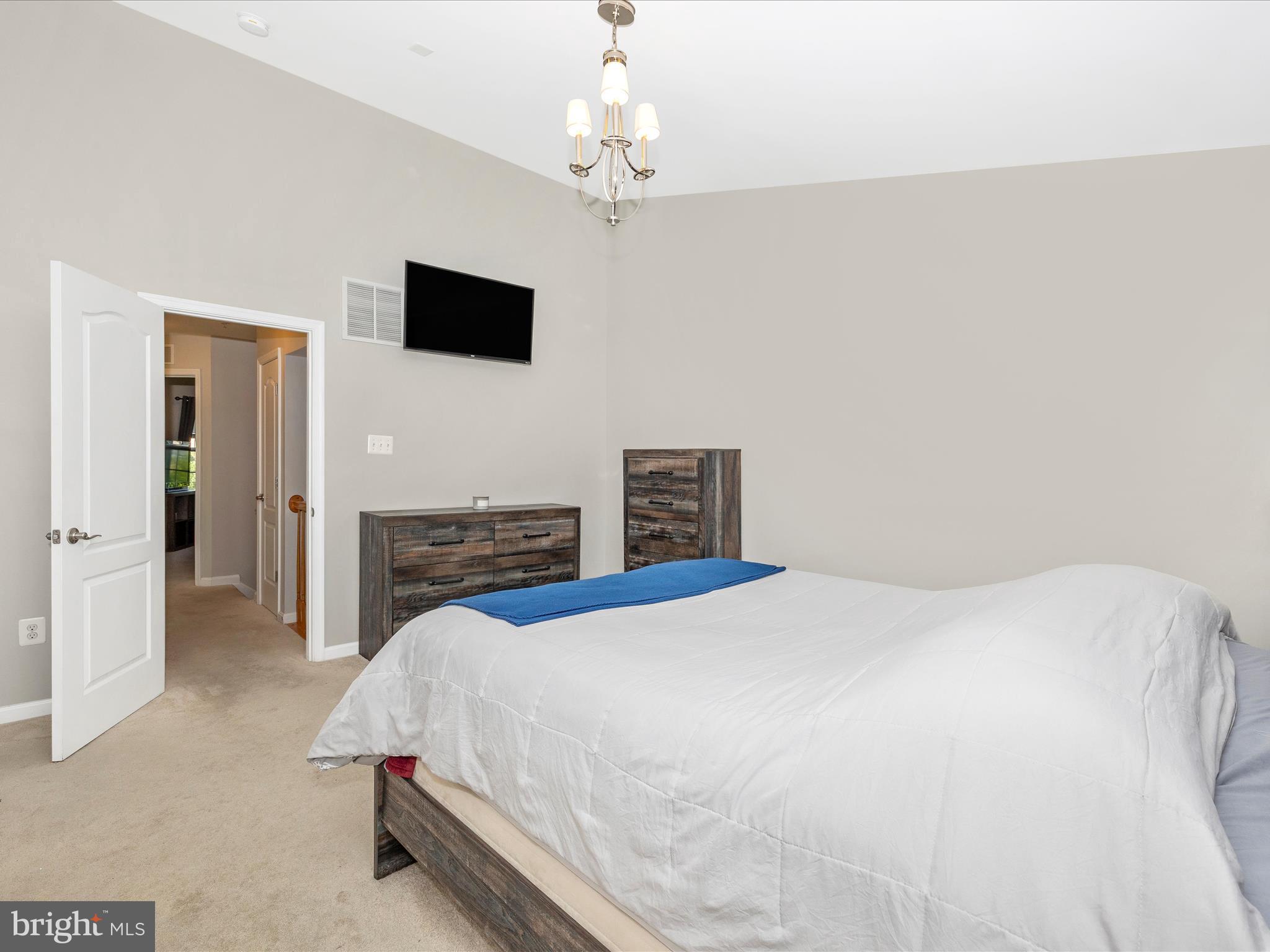 7801 Wormans Mill Road Frederick, MD 21701 - Photo 22 of 35 a spacious bedroom with a bed and a flat screen tv