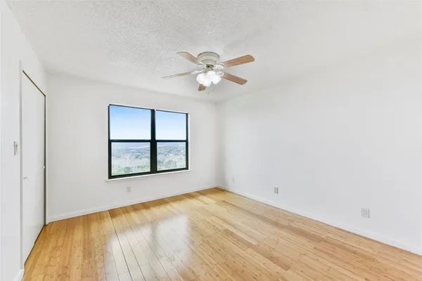 a view of a room with a window and wooden floor
