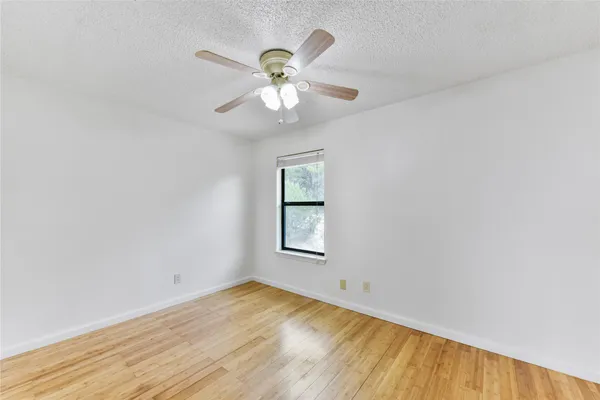 an empty room with a window and wooden floor