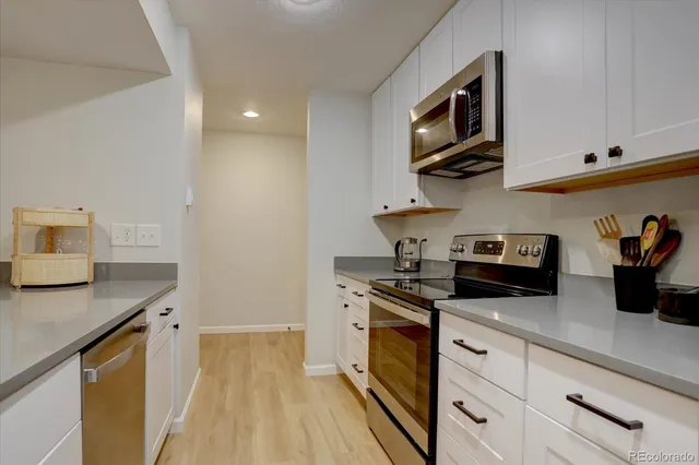 a kitchen with stainless steel appliances granite countertop a sink a stove and cabinets