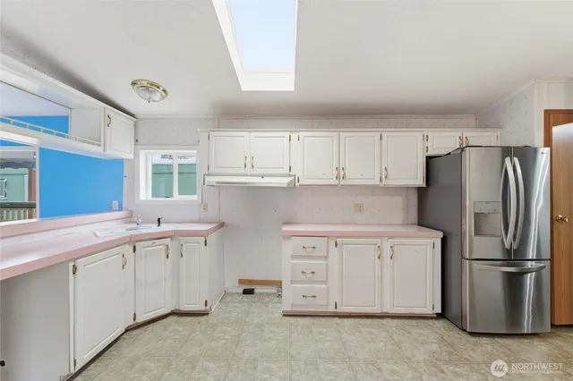 a kitchen with stainless steel appliances a refrigerator sink and cabinets