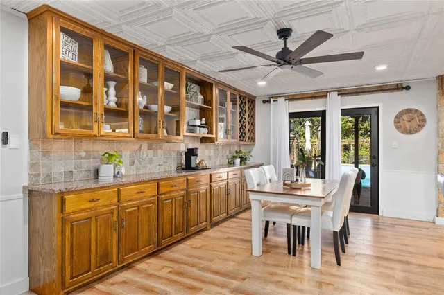 a kitchen with granite countertop a dining table chairs and white cabinets