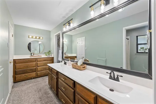 a bathroom with double vanity and a mirror