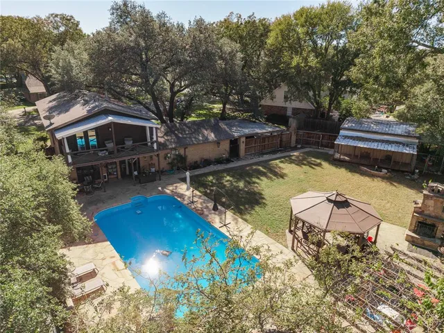 a view of a swimming pool with lawn chairs under an umbrella