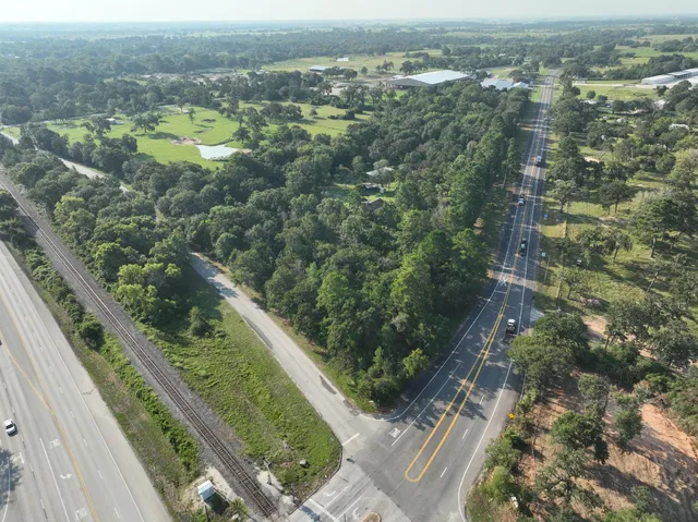 an aerial view of residential houses with outdoor space and trees
