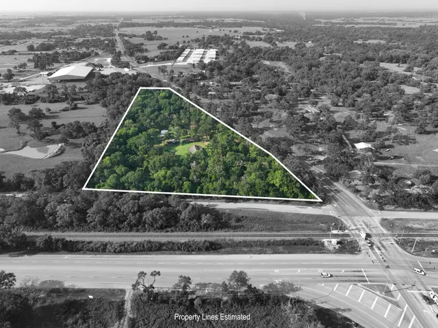 an aerial view of residential houses with outdoor space and parking