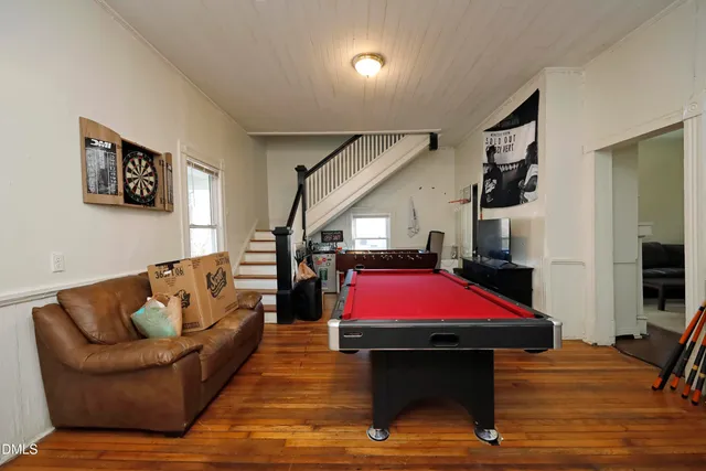 a living room with furniture pool table and a flat screen tv