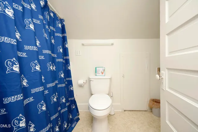 a white toilet sitting next to a white sink and vanity