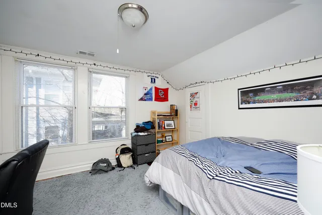 a bedroom with bed and a large window