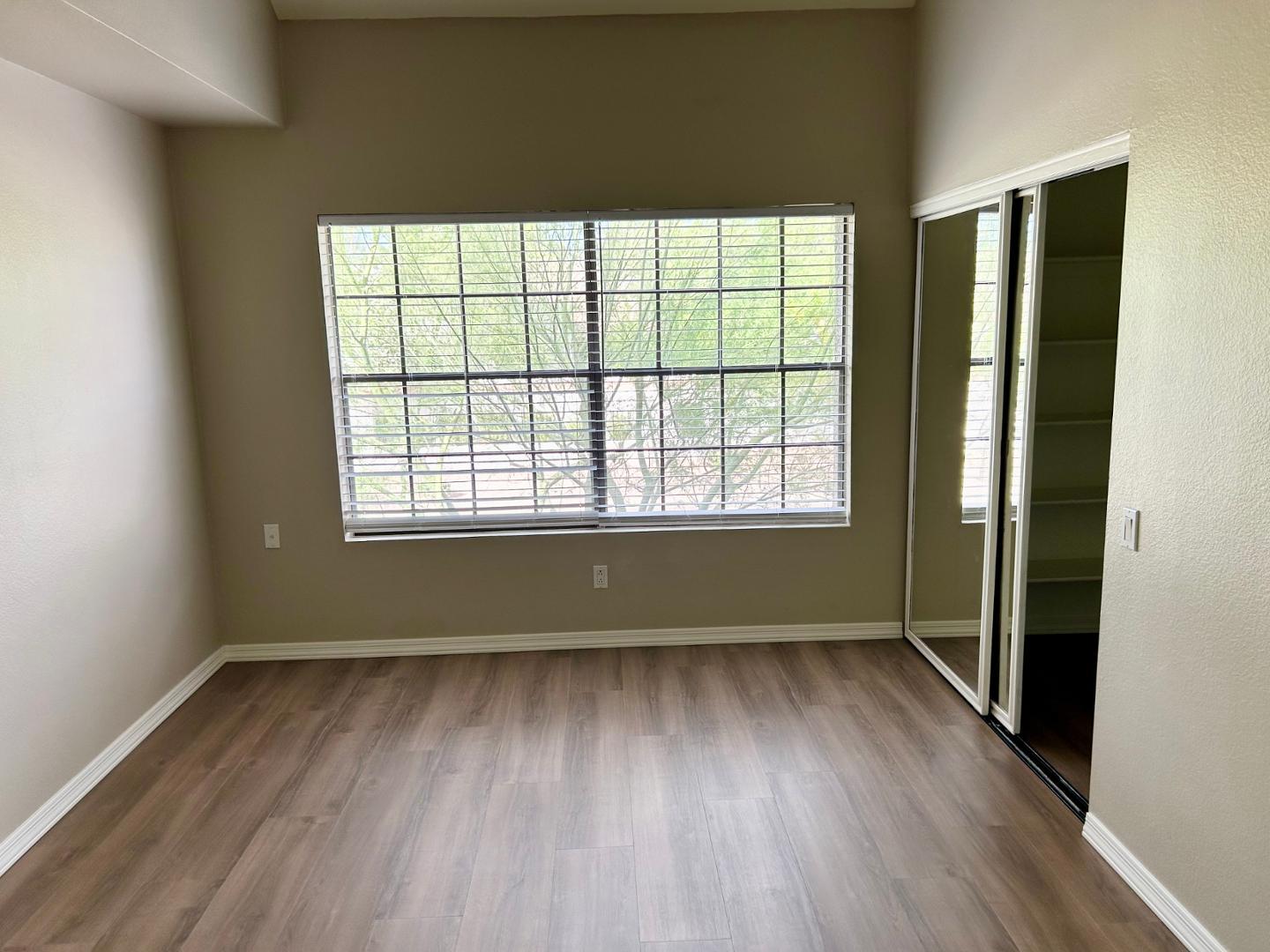 10015 East Mountain View Road, Unit 2009 Scottsdale, AZ 85258 - Photo 9 of 18 a view of an empty room with wooden floor and a window