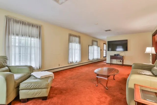 a kitchen with stainless steel appliances granite countertop a refrigerator a stove a sink and a dining table with many windows