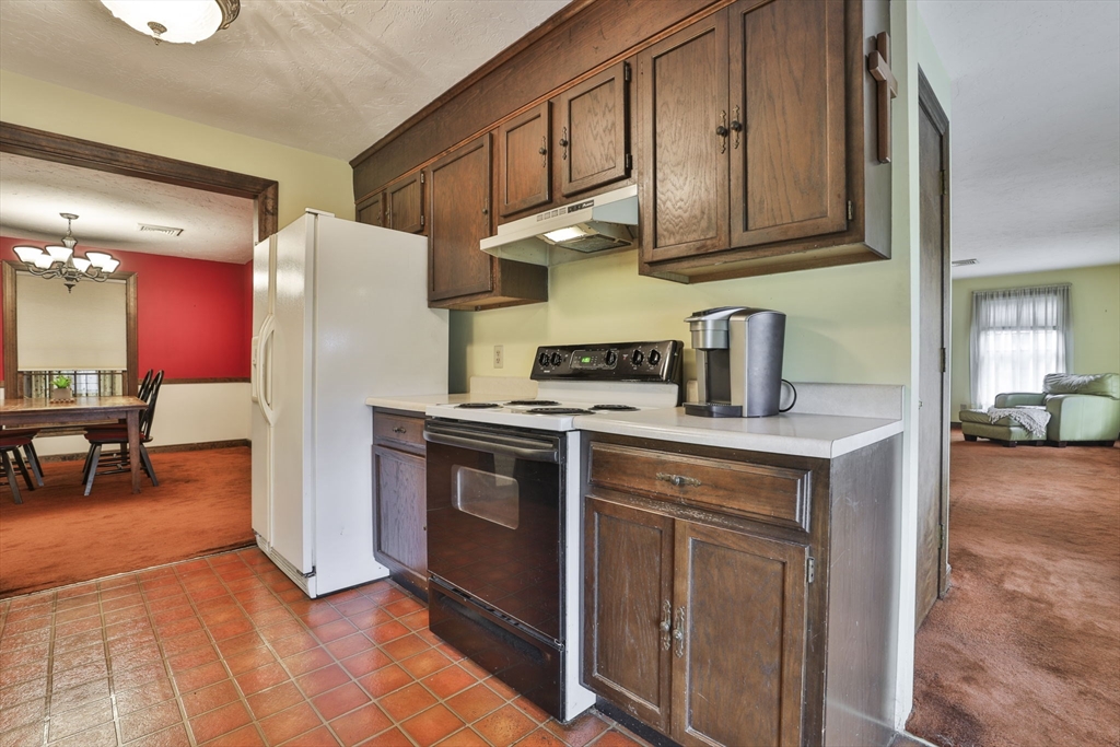 47 Sugar Road Bolton, MA 01740 - Photo 27 of 42 a kitchen with stainless steel appliances granite countertop a refrigerator a stove a sink and a dining table with many windows