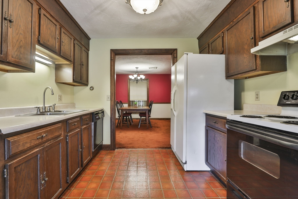 47 Sugar Road Bolton, MA 01740 - Photo 29 of 42 a kitchen with stainless steel appliances granite countertop a stove a sink dishwasher and a refrigerator with wooden cabinets