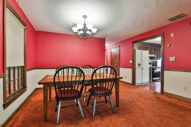 a dining room with furniture and a chandelier
