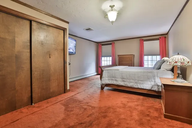 a spacious bedroom with a bed closet and wooden floor