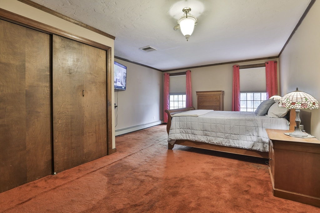 47 Sugar Road Bolton, MA 01740 - Photo 34 of 42 a bedroom with a bed and a chandelier